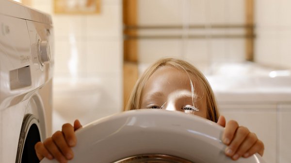 Dziewczynka przed pralką – obniżenie kosztów energii