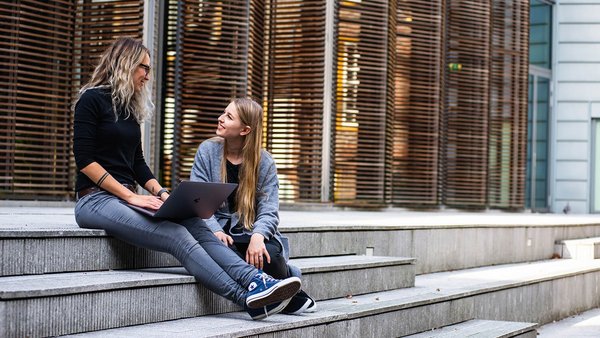 Studentki siedzą na schodach śmiejąc się Studentki siedzą na schodach śmiejąc się