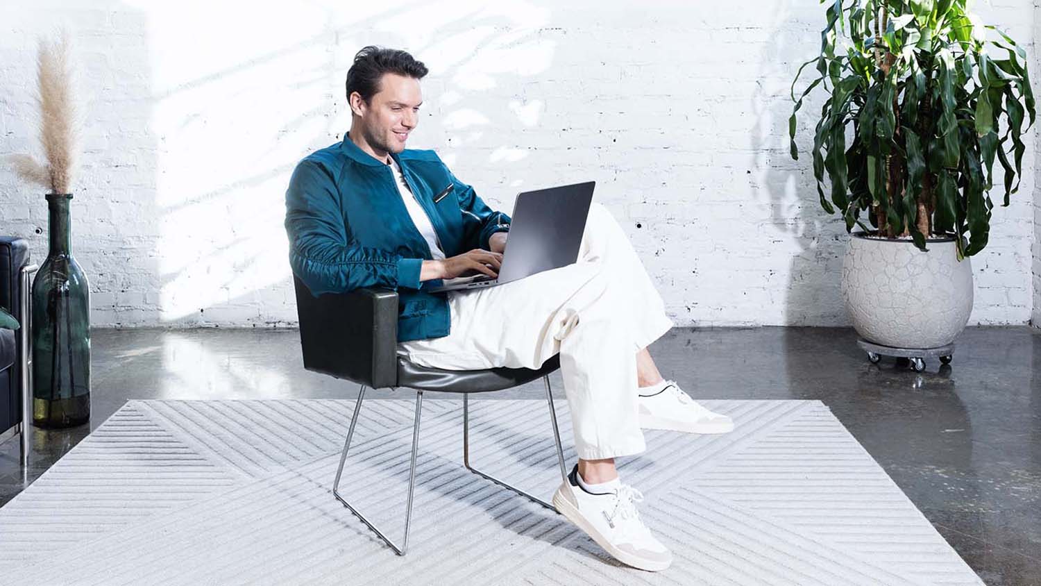 Młody człowiek pracuje przy laptopie i planuje swój budżet.