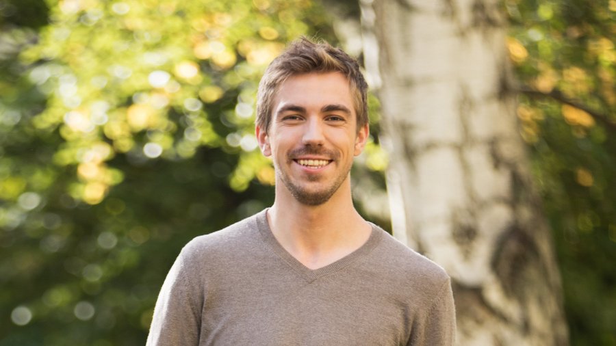 Uśmiechnięty młody mężczyzna w parku