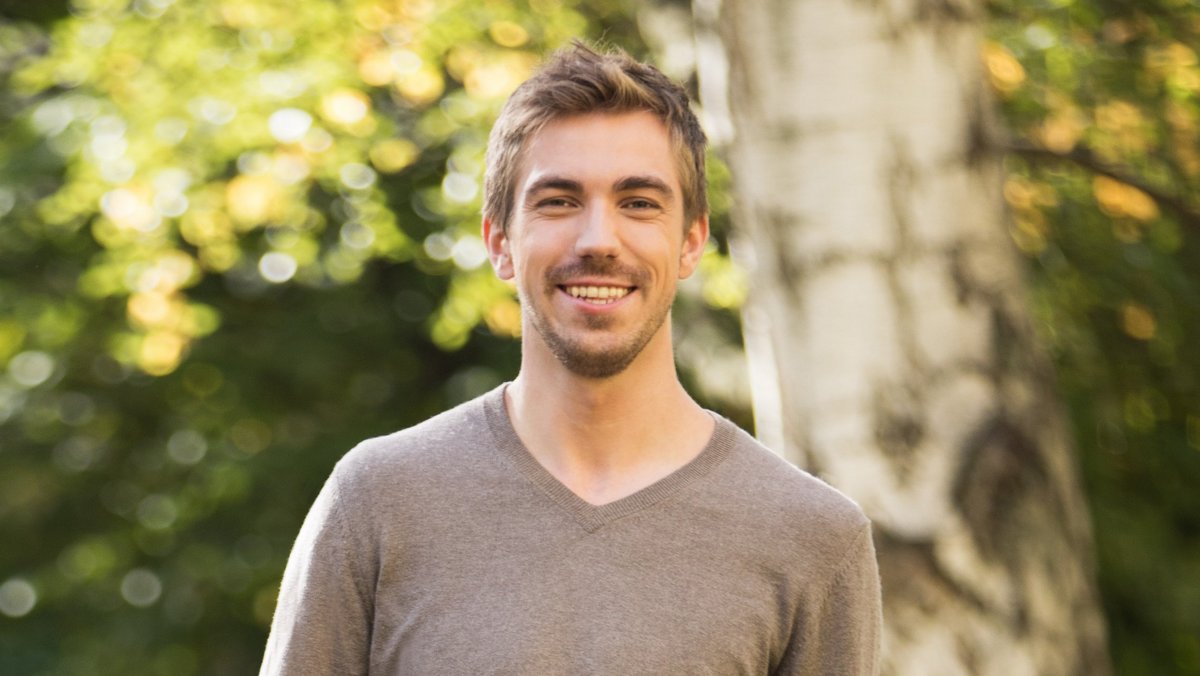 Uśmiechnięty młody mężczyzna w parku