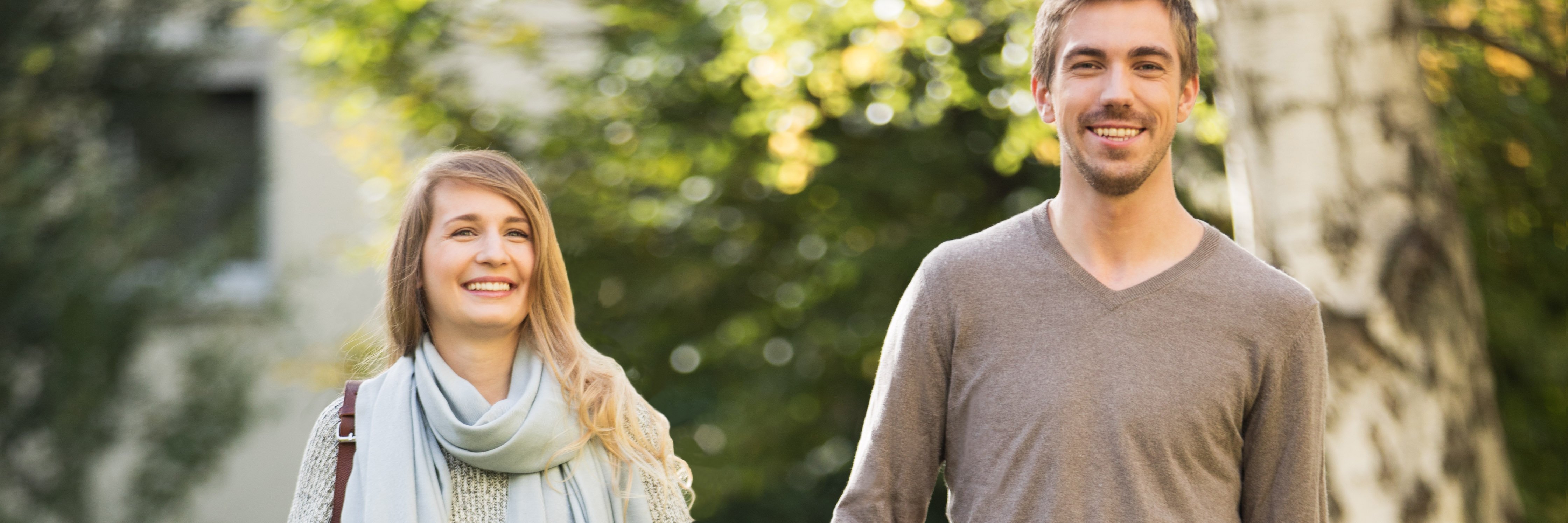 Młoda para uśmiechnięta podczas spaceru w parku