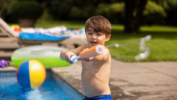 Dziecko przy basenie z pistoletem na wodę - podróżuj bezpiecznie  